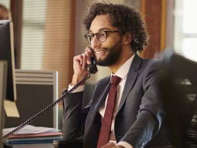 Man sitting at a desk talking on the phone
