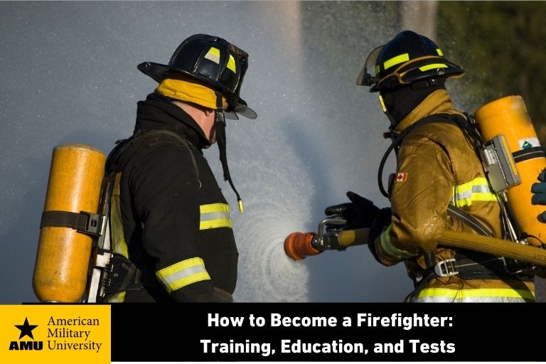 firefighter holding hose spraying water on flames
