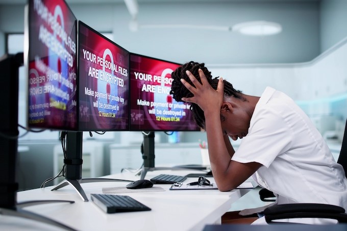 girl at computer with ransomware on screen