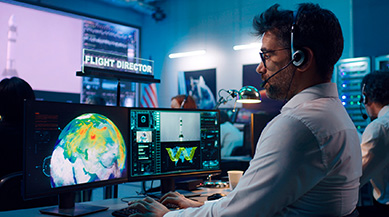 cybersecurity professional looking at computer monitor in dimly lit room