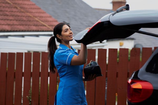 nurse shutting car trunk